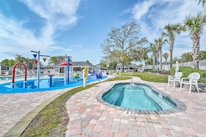 A swimming pool area with a small pool, a water slide, and lounge chairs. - Surfside Beach Home w/ Resort Perks: Walk to Beach (Murrells Inlet)