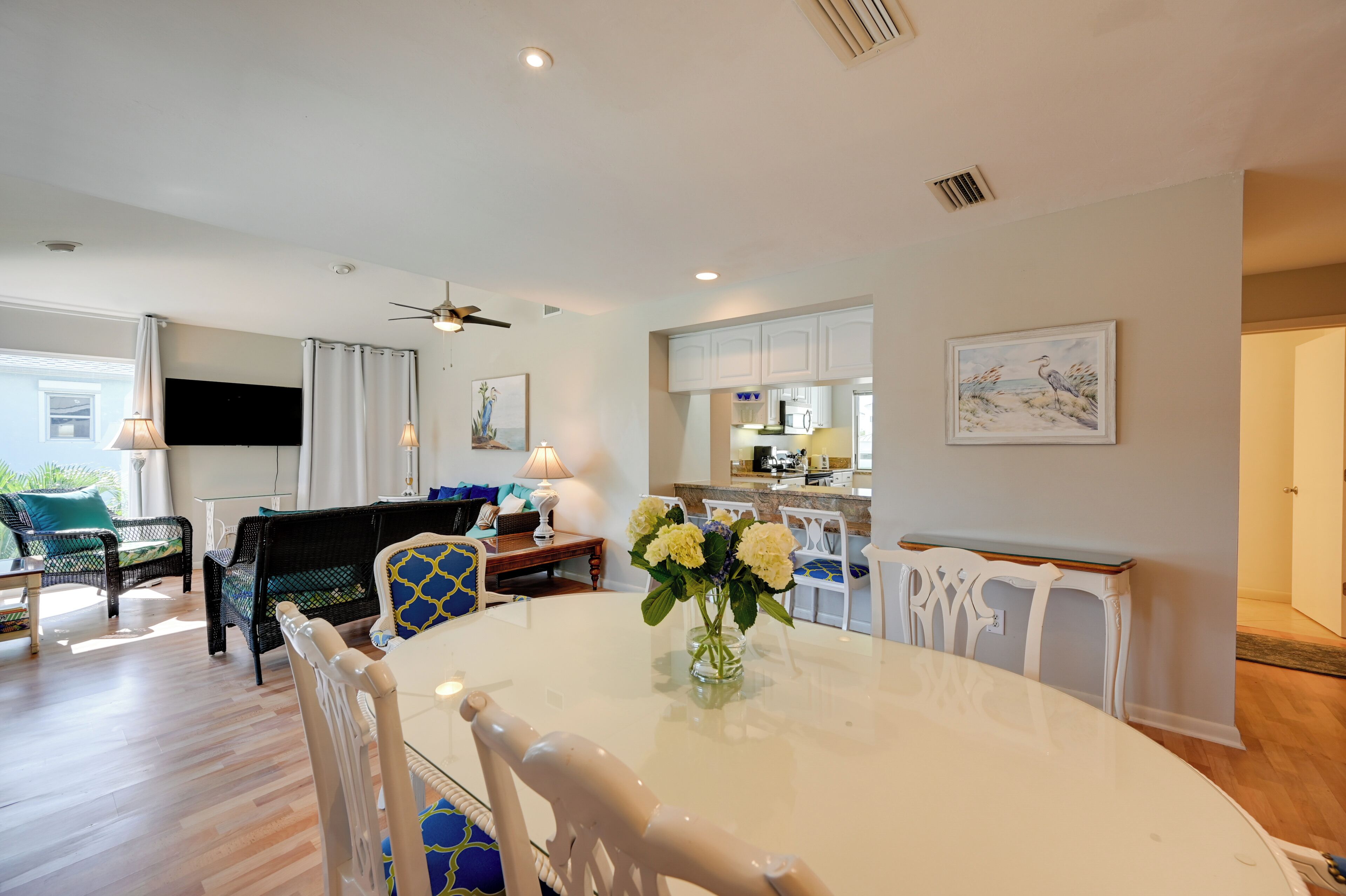 Una sala de estar moderna con una mesa de comedor, sillas y un televisor de pantalla plana.