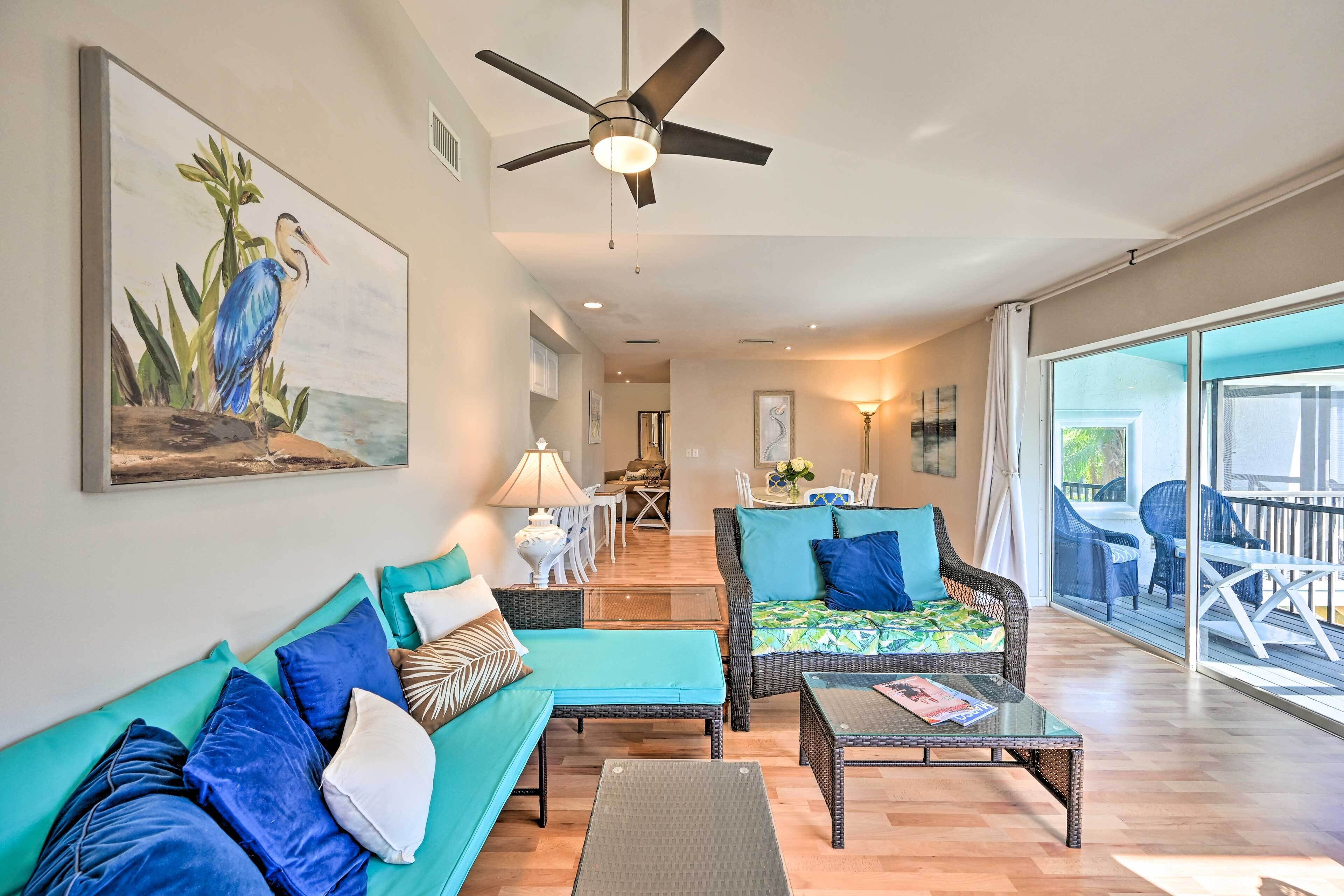 A spacious living area with a ceiling fan, a dining table with chairs, and a large sliding glass door leading to an outdoor patio.