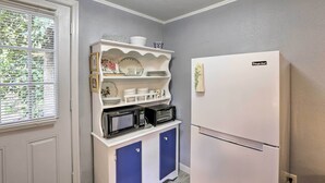 A kitchen with a white refrigerator, a microwave, and a built-in shelf with dishes and a coffee maker. - 'the Driftwood Cottage' w/ Patio & Free Wifi! (Quincy)