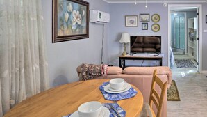 A dining area with a wooden table set for two, a sofa, and a TV. - 'the Driftwood Cottage' w/ Patio & Free Wifi! (Quincy)