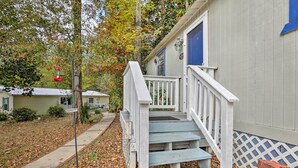 A wooden staircase leading to a house with a blue door, surrounded by trees and a leaf-covered ground. - 'the Driftwood Cottage' w/ Patio & Free Wifi! (Quincy)