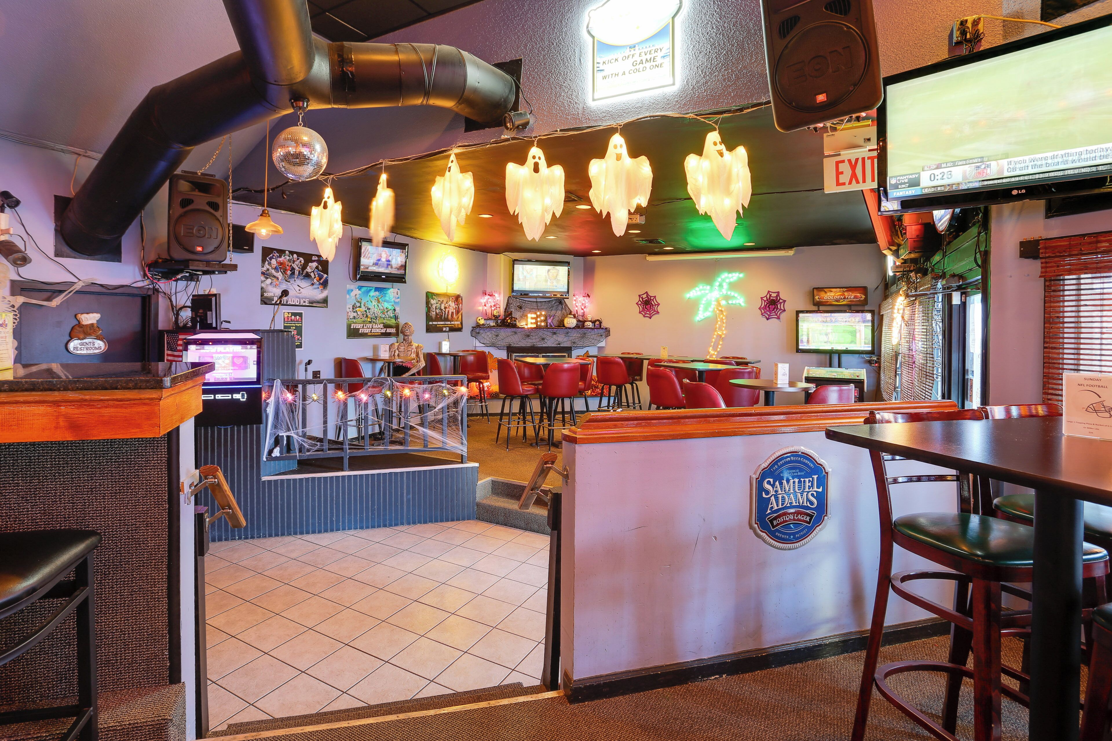 Eine Bar mit Jukebox, mehreren Fernsehern und einer Neonreklame.