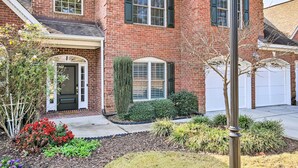 A two-story brick house with a front door, a garage, and a well-maintained garden with various plants and flowers. - Upscale Home w/ Poker Room < 1 Mi to Golf! (Aiken)