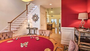 A room with a red carpet, a poker table, a chandelier, and a staircase. - Upscale Home w/ Poker Room < 1 Mi to Golf! (Aiken)