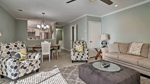 Un salon comprenant un canapé, des fauteuils, une table basse et un coin repas avec une table et des chaises.