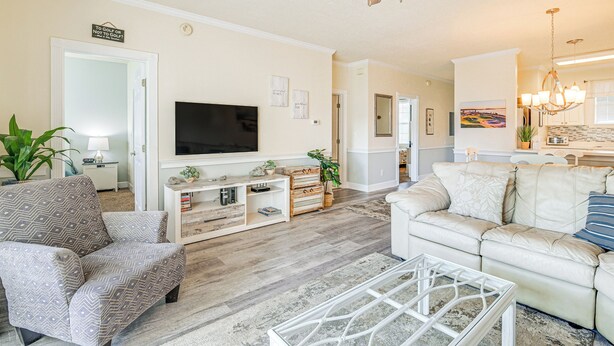 A living room with a TV, sofas, a coffee table, and a ceiling fan. - Pools & Golf, 2 Mi to Beach: Myrtle Beach Condo! (Myrtle Beach)