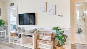 A living room with a TV, wooden storage boxes, and two motivational wall art pieces. - Pools & Golf, 2 Mi to Beach: Myrtle Beach Condo! (Myrtle Beach)