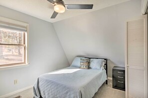 A bedroom with a bed, a ceiling fan, a window, and a wardrobe. - Waterfront Chapin Home w/ Private Dock! (Chapin)