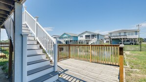 A wooden deck with a white railing leading to a house with a blue exterior. - Waterfront Home w/ Deck in North Myrtle Beach! (North Myrtle Beach)