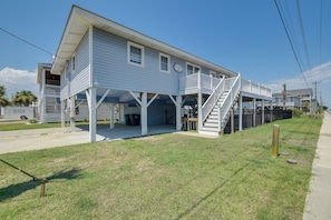 A two-story house with a covered porch and a staircase leading to the upper floor.