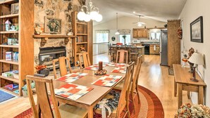 A spacious dining area with a stone wall, wooden furniture, and a fireplace. - 40-acre Poplar Bluff Nature Lovers Paradise! (Poplar Bluff)