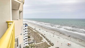 Blick auf einen Strand vom Balkon mit gelander, Sandstrand und Wellen.