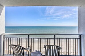 Ein Balkon mit zwei Stühlen, Blick auf den Strand.
