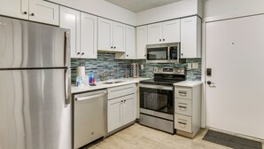 A kitchen with white cabinets, stainless steel appliances, a tiled backsplash, and a wooden floor. - 2 Blocks to Beach: Hilton Head Condo, Pool, Tennis (Hilton Head Island)