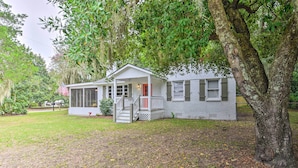 A two-story house with a porch, a small deck, and a front yard.