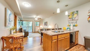 A spacious kitchen with wooden cabinets, a central island, and pendant lighting. - Accessible Branson Condo: Balcony + Lake Access! (Branson West)