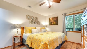 A bedroom with a bed, bedside tables, a ceiling fan, a window, and a painting on the wall. - Accessible Branson Condo: Balcony + Lake Access! (Branson West)