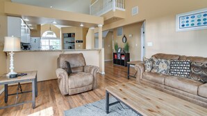A spacious living area with a high ceiling, a dining table, a leather armchair, and a sofa with patterned cushions. - Branson Condo w/ Pool: 2 Mi to Table Rock Lake (Branson)