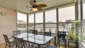 A sunroom with a glass table and chairs, a ceiling fan, and large windows offering a view of the neighborhood. - Branson Condo w/ Pool: 2 Mi to Table Rock Lake (Branson)