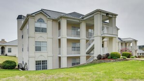 A multi-story residential building with a balcony on the second floor, a covered front porch, and a landscaped front yard. - Branson Condo w/ Pool: 2 Mi to Table Rock Lake (Branson)