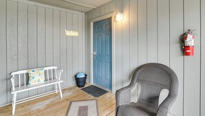 A wooden bench with a cushion, a blue door, a fire extinguisher, and a chair. - Branson Condo w/ Views - Near Silver Dollar City! (Branson West)