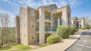 A multi-story residential building with a central courtyard, balconies, and a parking area. - Branson Condo w/ Balcony, Near Silver Dollar City! (Branson)
