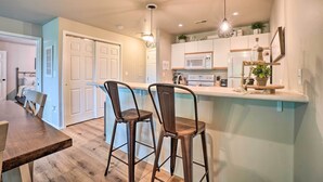A modern kitchen with a central island, bar stools, and pendant lighting. - Branson Condo ~ 6 Mi to Silver Dollar City! (Branson)