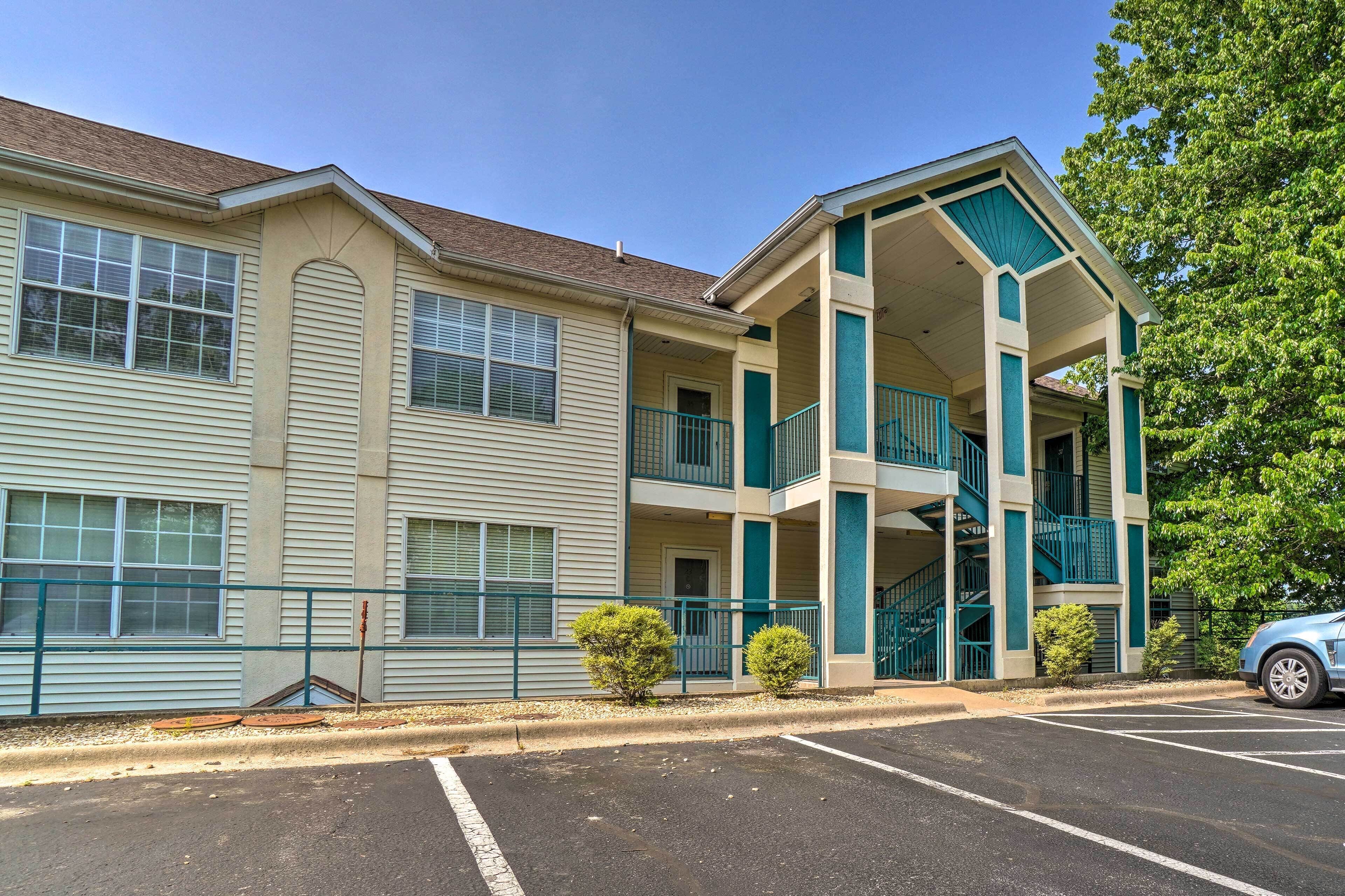 A multi-story hotel with a central atrium, a parking lot, and a blue car parked in front.