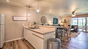 A modern kitchen with a central island, pendant lighting, and a dining area with a sofa and chairs. - Branson Condo ~ 6 Mi to Silver Dollar City! (Branson)