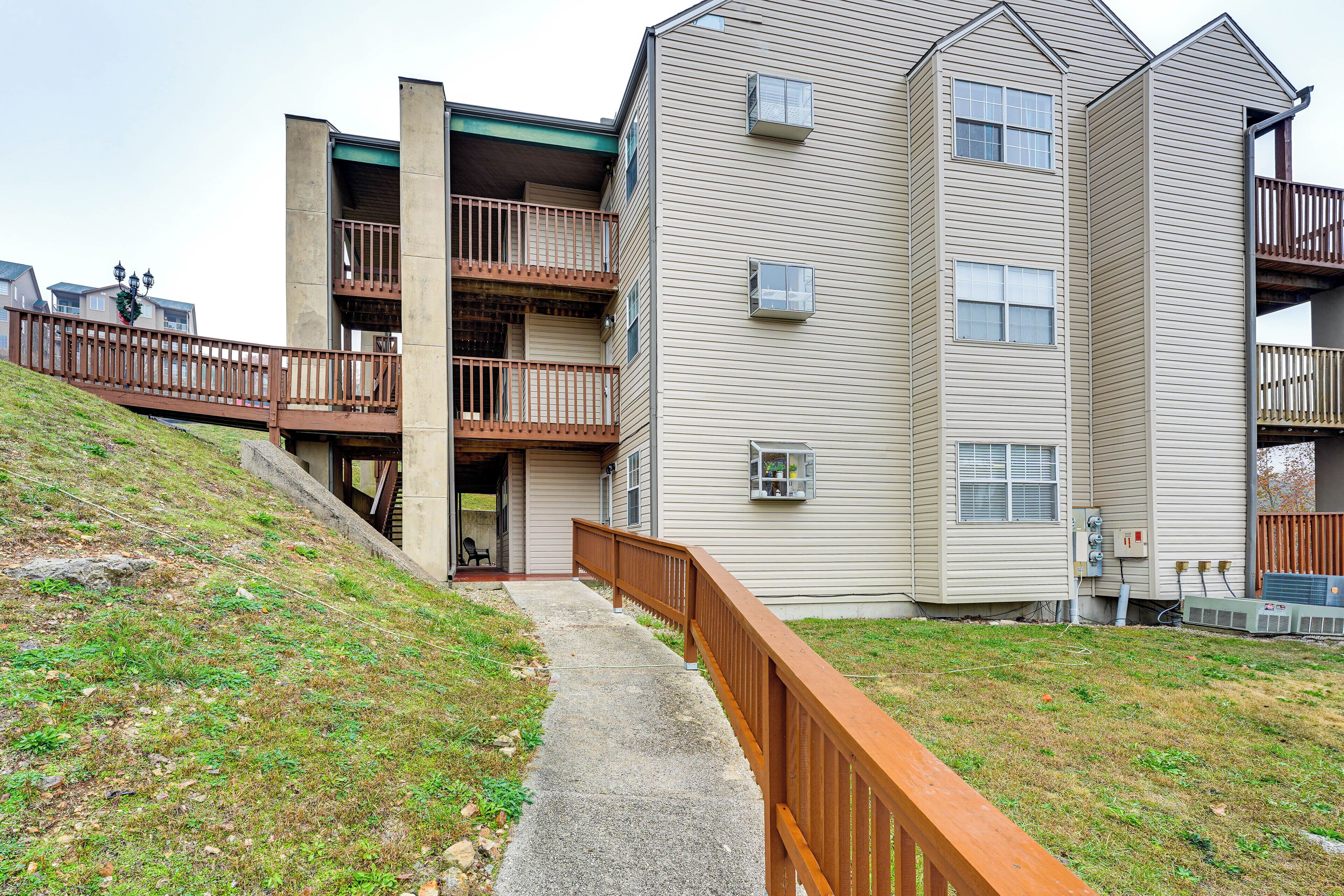 A multi-story residential building with a concrete pathway leading to the entrance.