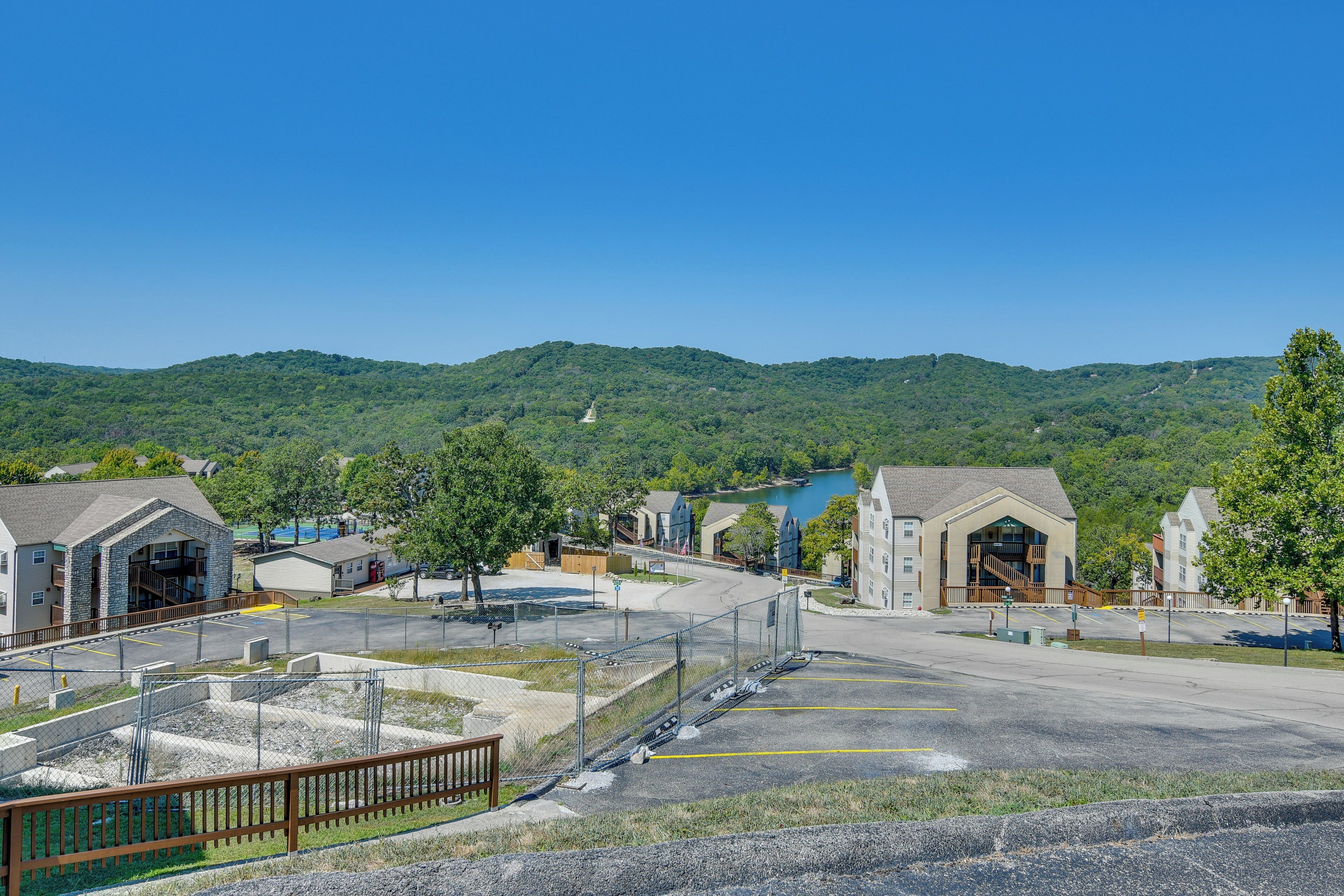 A parking lot with a view of a residential area and hills in the background.