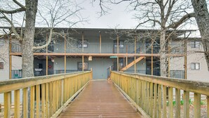 A wooden bridge leading to a building with a balcony and a staircase. - Family-friendly Condo: 1 Mi to Silver Dollar City! (Branson West)