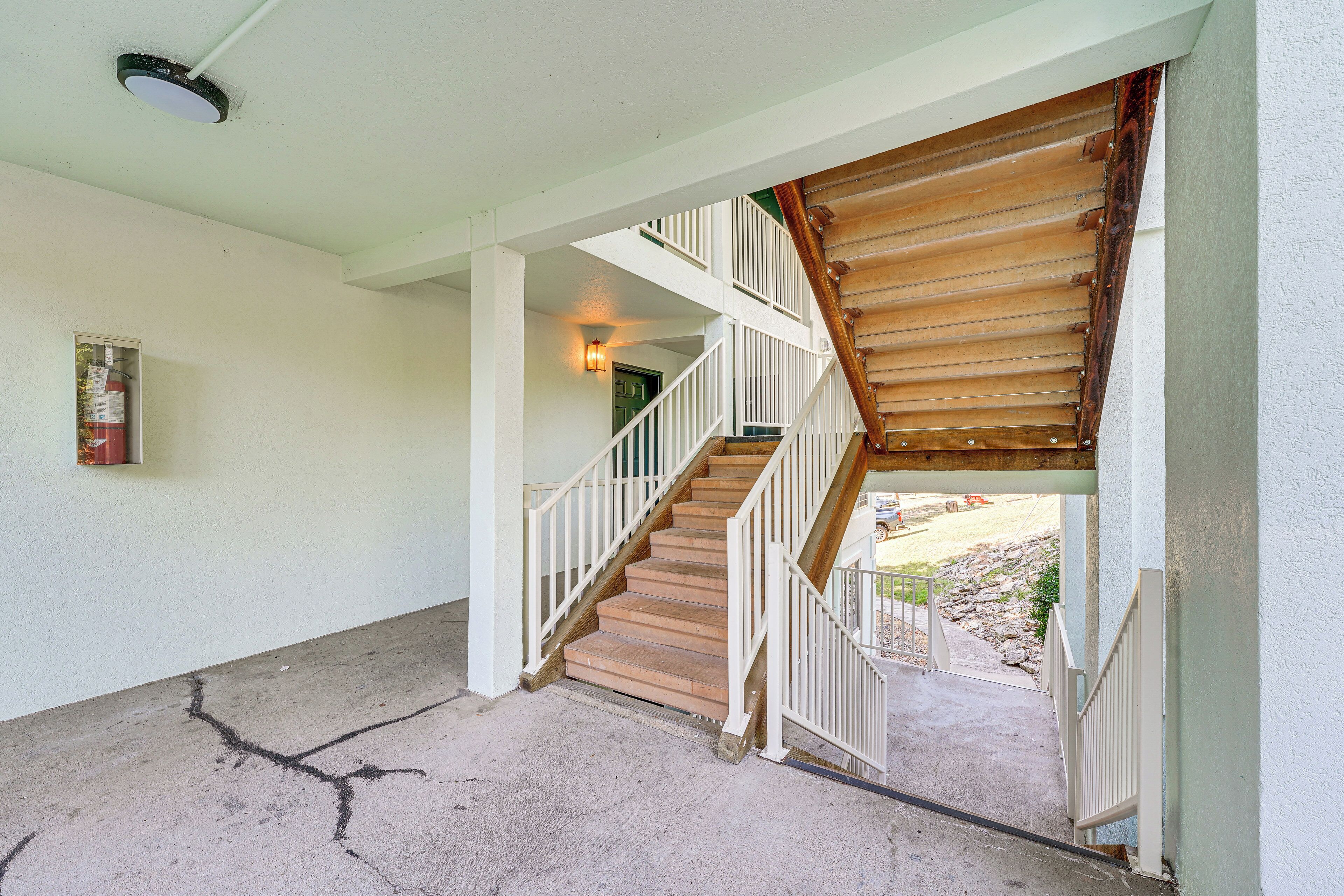 A staircase with white railings and wooden steps leading to a second floor.