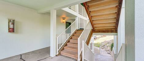 A staircase with white railings and wooden steps leading to a second floor.