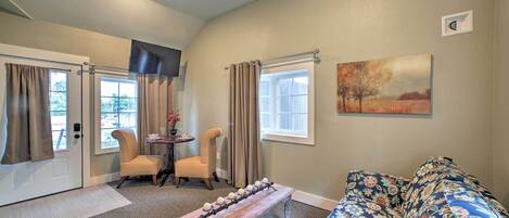 A living room with a sofa, a coffee table, a TV, and a painting on the wall.
