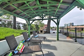 An outdoor patio with metal-framed chairs and a green roof structure. - 2 Mi to Branson Strip: Cozy Cottage w/ Fire Pit! (Branson)