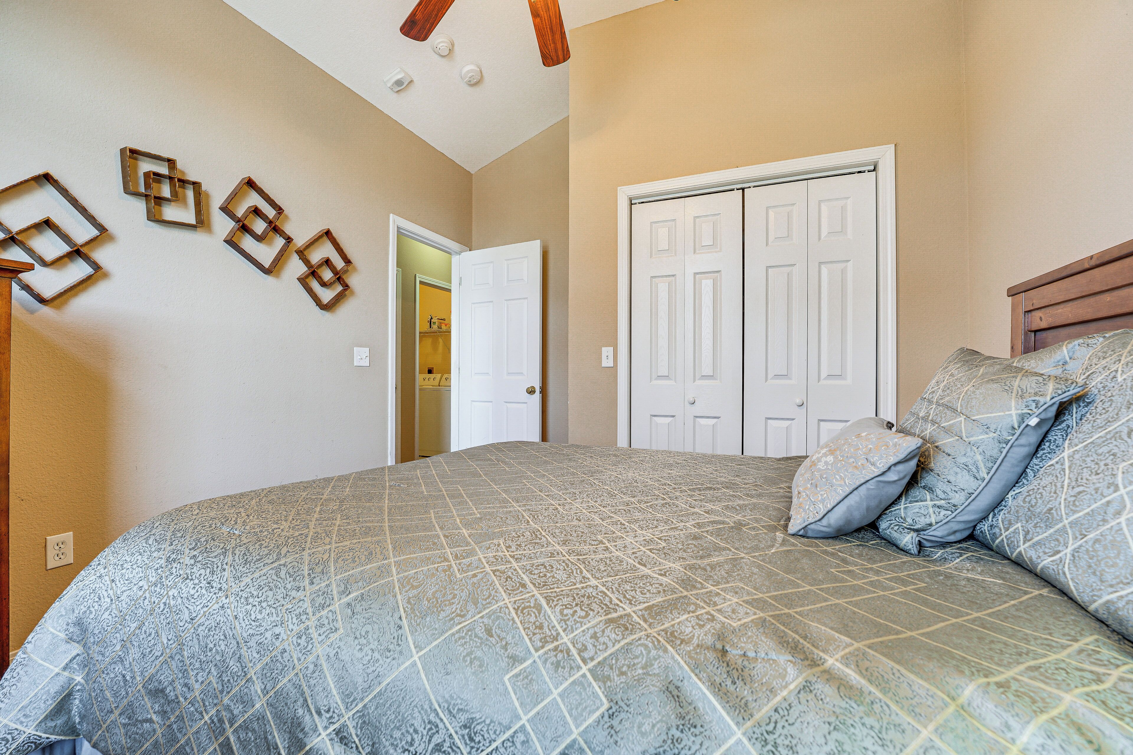 A bedroom with a large bed, a wardrobe, and a door leading to a bathroom.