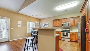 A modern kitchen with wooden cabinets, stainless steel appliances, and a central island. - Walk to The Strip: Family-friendly Branson Home (Branson)