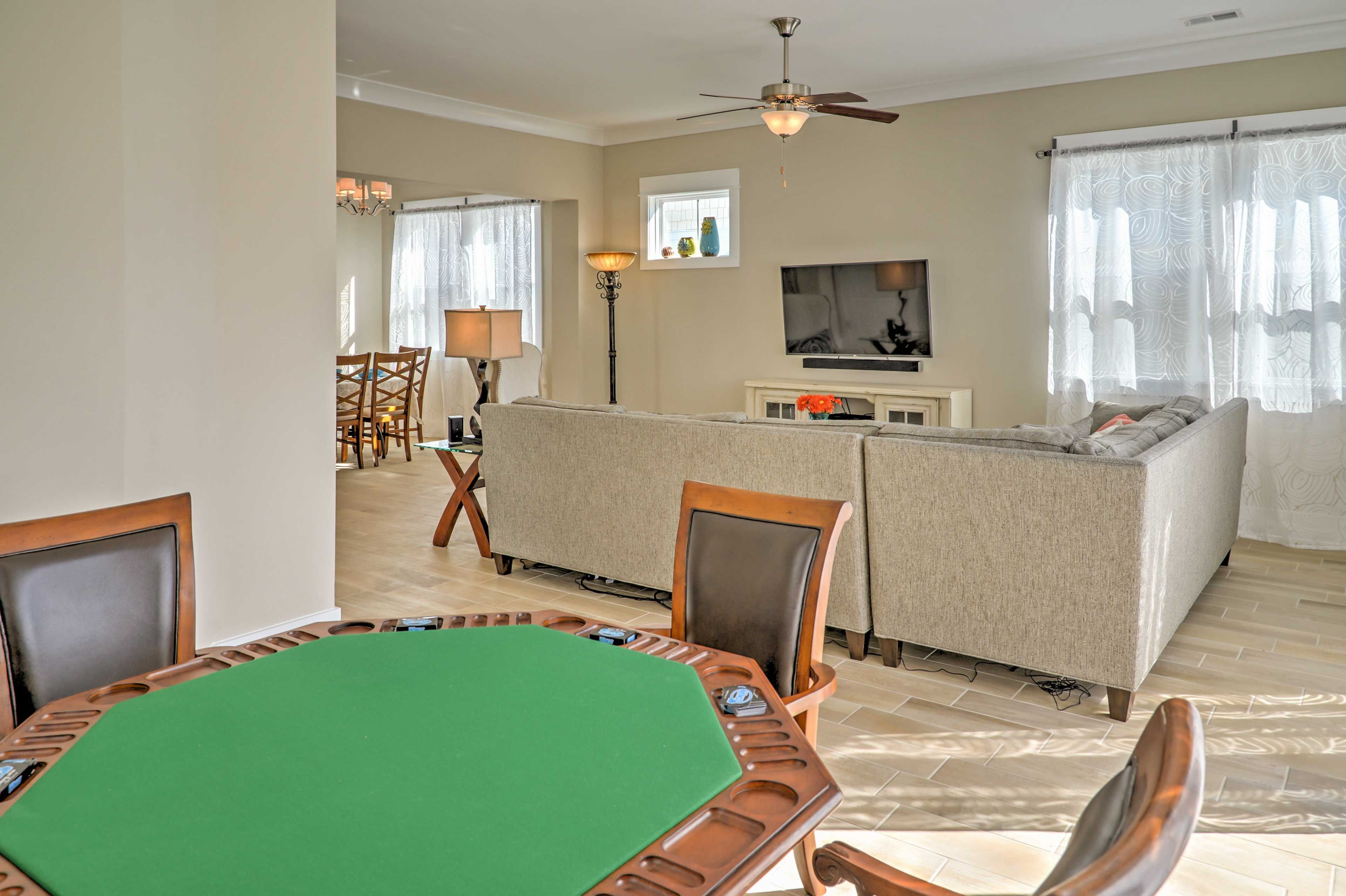 A living room with a green pool table, a sofa, and a television.