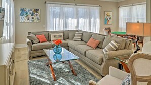 A living room with a sectional sofa, a glass coffee table, and a "WELCOME" sign. - 1 Block to Beach! Breezy Myrtle Beach Getaway (Myrtle Beach)