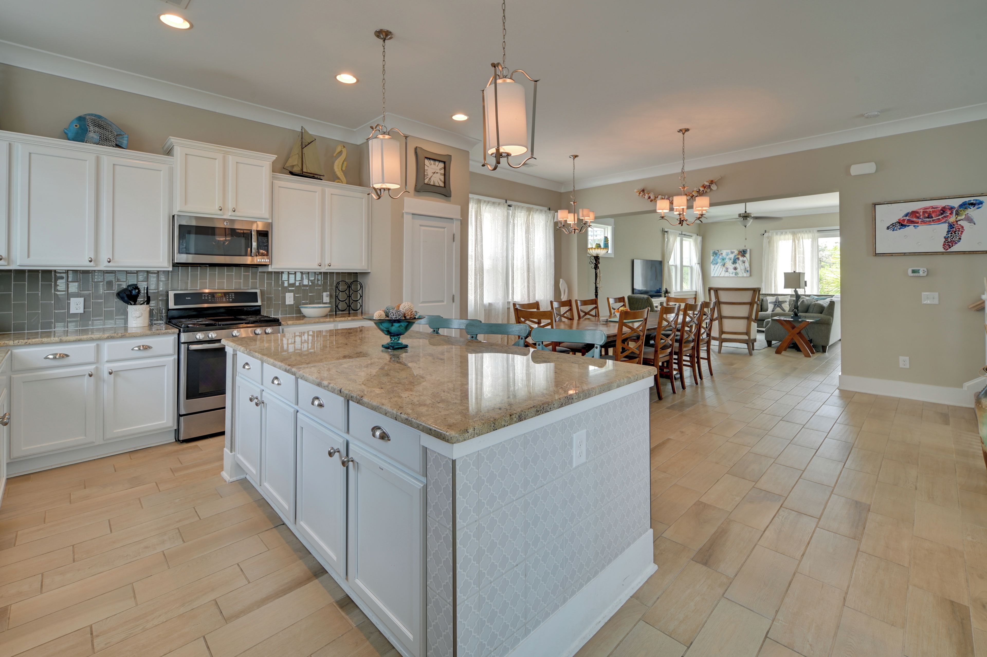A spacious kitchen with white cabinets, a large island, and modern appliances.