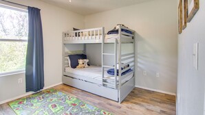 A bunk bed room with a ceiling fan, a window with curtains, and a colorful rug. - Walk-in Unit, No Stairs, Pool! Family Fun Awaits (Branson)