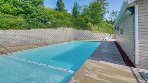 A swimming pool with a concrete deck, surrounded by a brick wall and greenery. - Walk-in Unit, No Stairs, Pool! Family Fun Awaits (Branson)