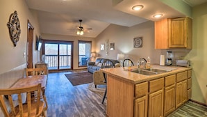 A spacious kitchen with wooden cabinets, a central island, and a dining area with a wooden table and chairs. - Branson West Condo Rental w/ Pool Access! (Branson West)