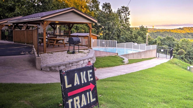 A lakeside lodge with a covered patio, a swimming pool, and a sign indicating a lake trail. - Branson West Condo Rental w/ Pool Access! (Branson West)