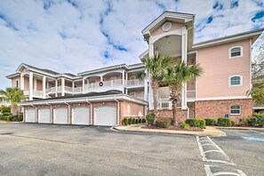 A multi-story residential building with a central garage, a covered front porch, and a brick facade. - Bright Myrtle Beach Condo w/ Balcony! (Myrtle Beach)