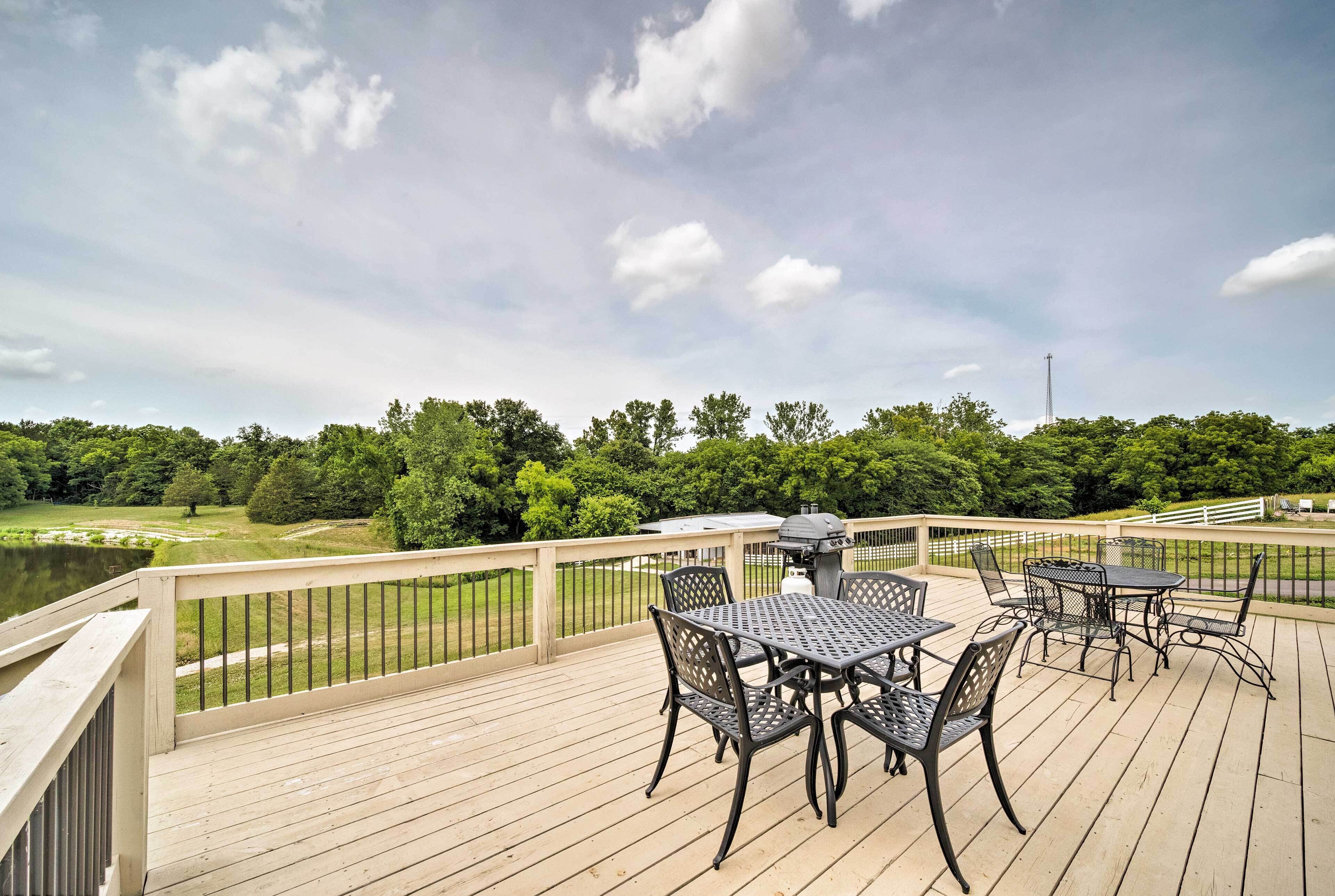 A wooden deck with outdoor furniture and a view of a golf course.