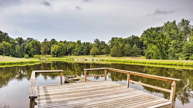 A wooden dock extending into a calm lake surrounded by lush greenery. - Charming Berger Apt on 42-acre Farm w/ Pool Access (Berger)