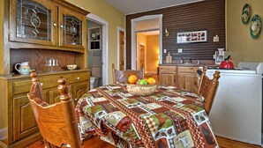 A dining area with a wooden table, chairs, and a fruit basket. - Charming Berger Apt on 42-acre Farm w/ Pool Access (Berger)